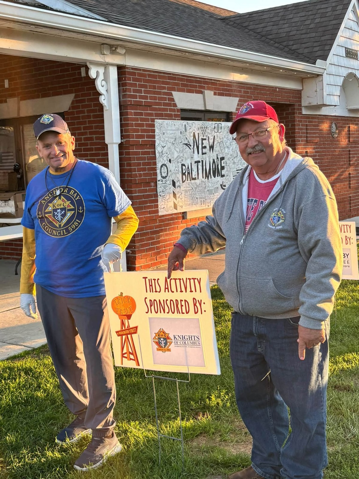 Steven Jewell and Dale Valliere beside the Knights of Columbus sponsor sign at the New Baltimore Trunk or Treat