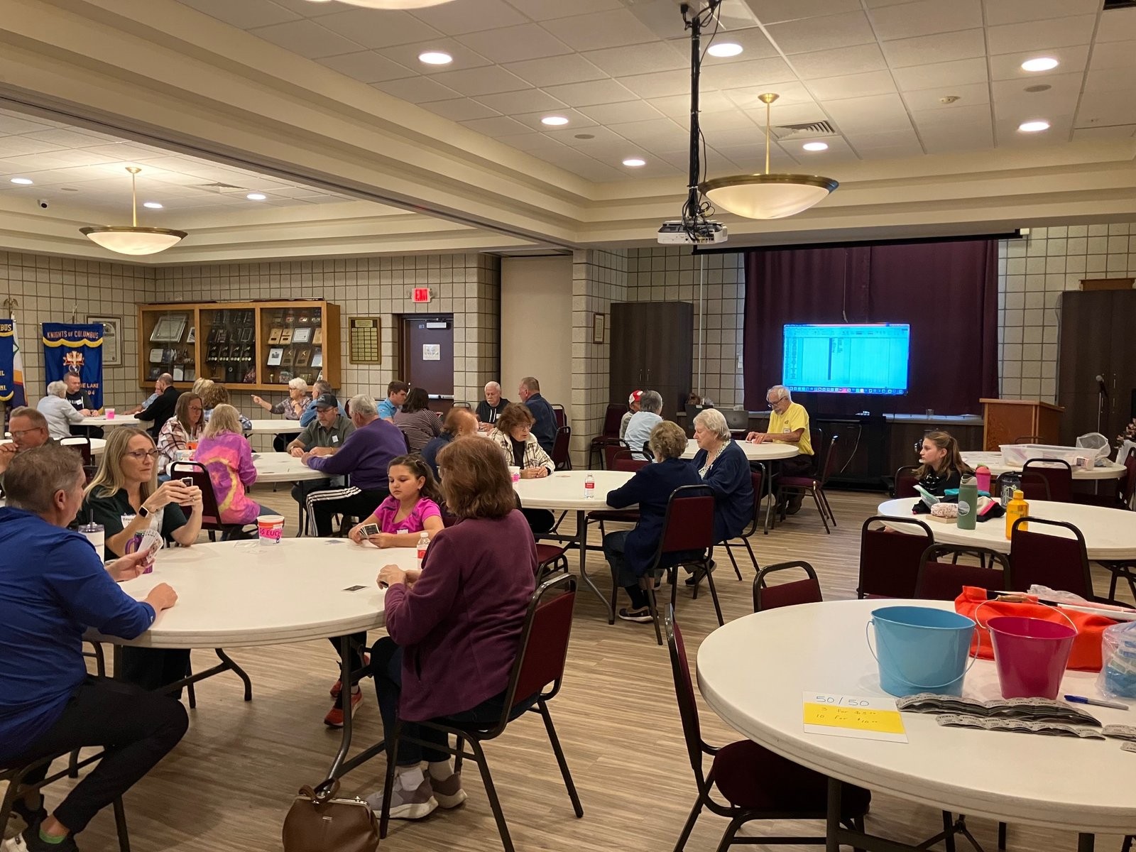 Guests playing cards at round tables during the Au Lac Council 10724 Euchre party fundraiser in Ira Township