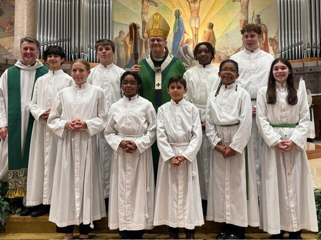 Archbishop Edward Weisenburger, Archbishop of Detroit, and a priest with altar servers at the St Clare of Montefalco Centennial Mass