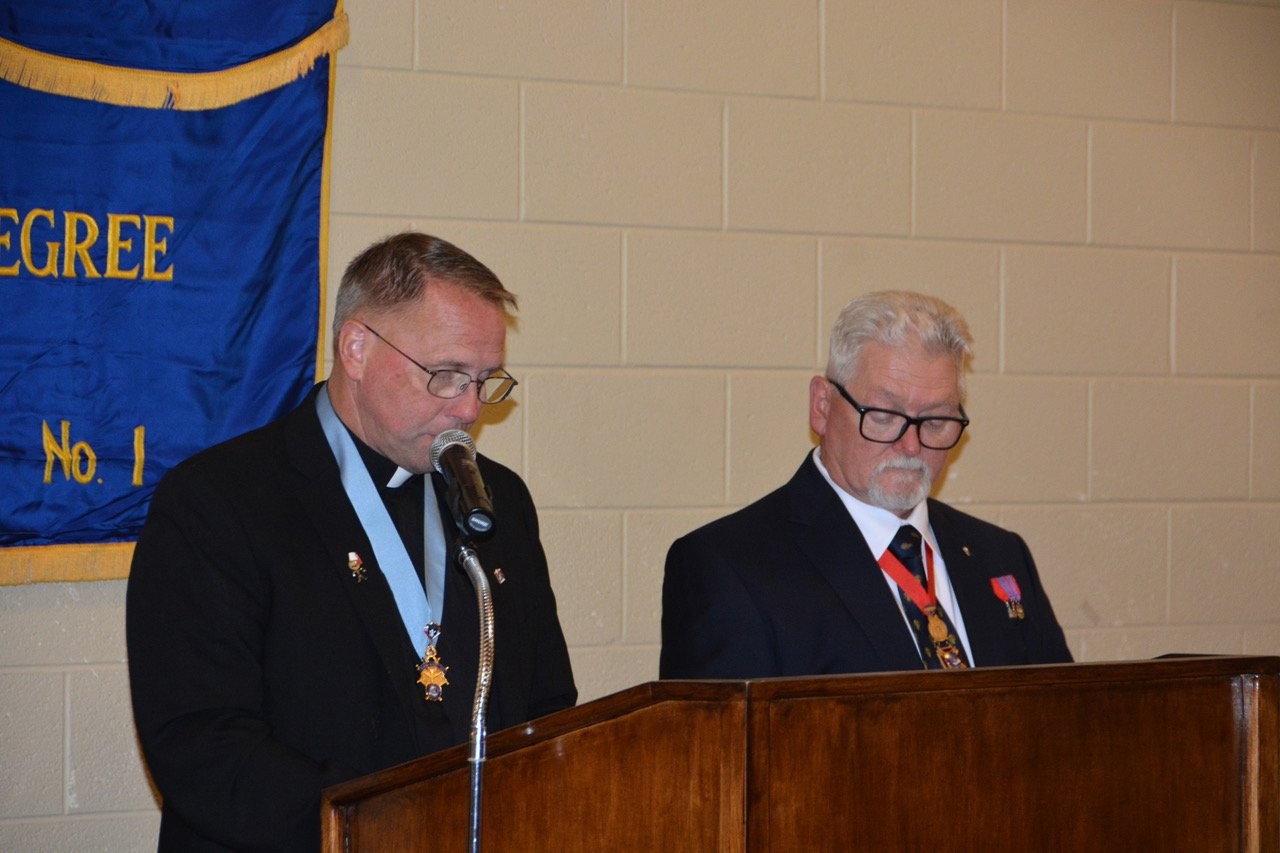 Priest leading a prayer at the podium