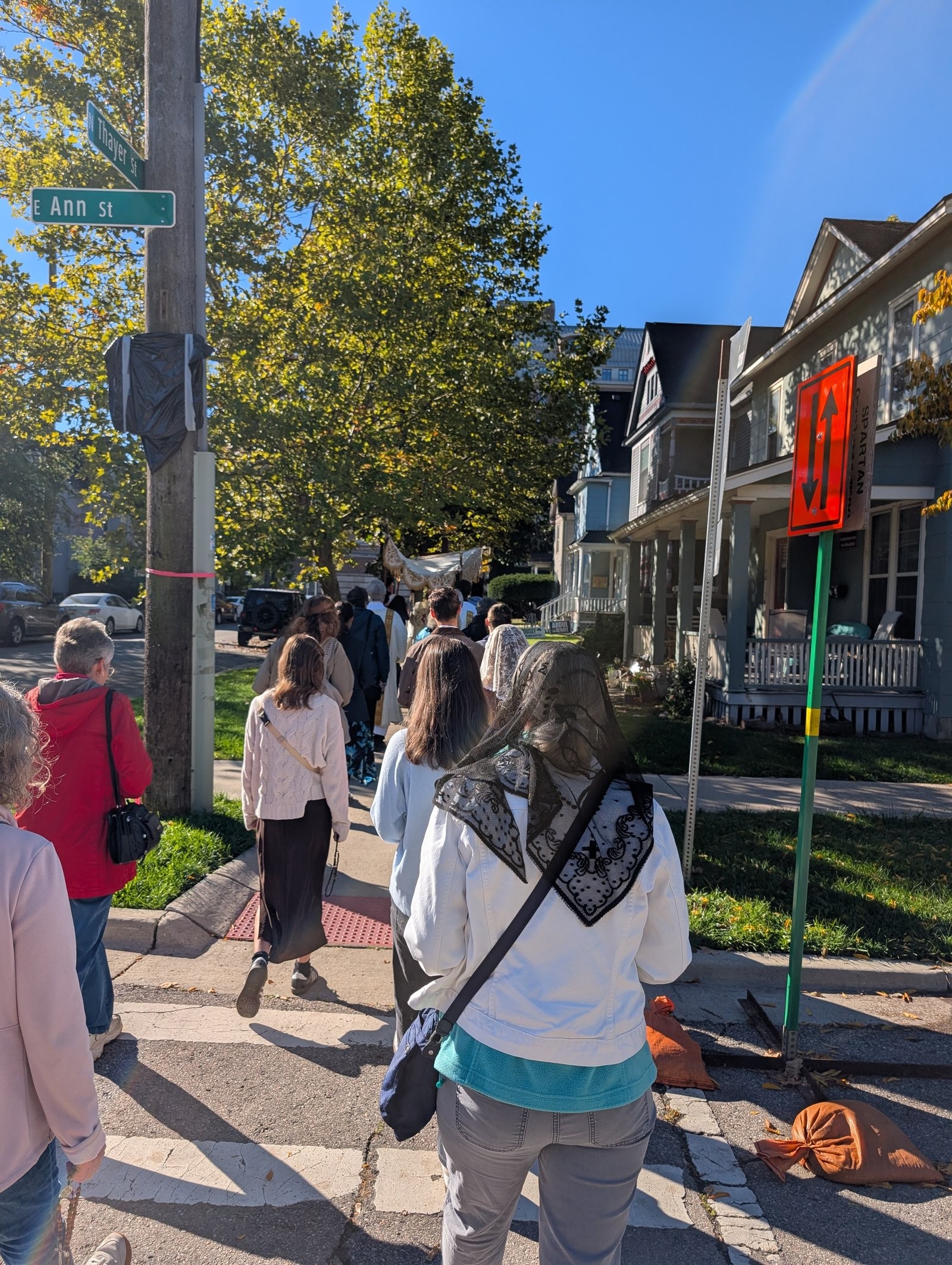 Procession participants walking along E Ann St in Ann Arbor