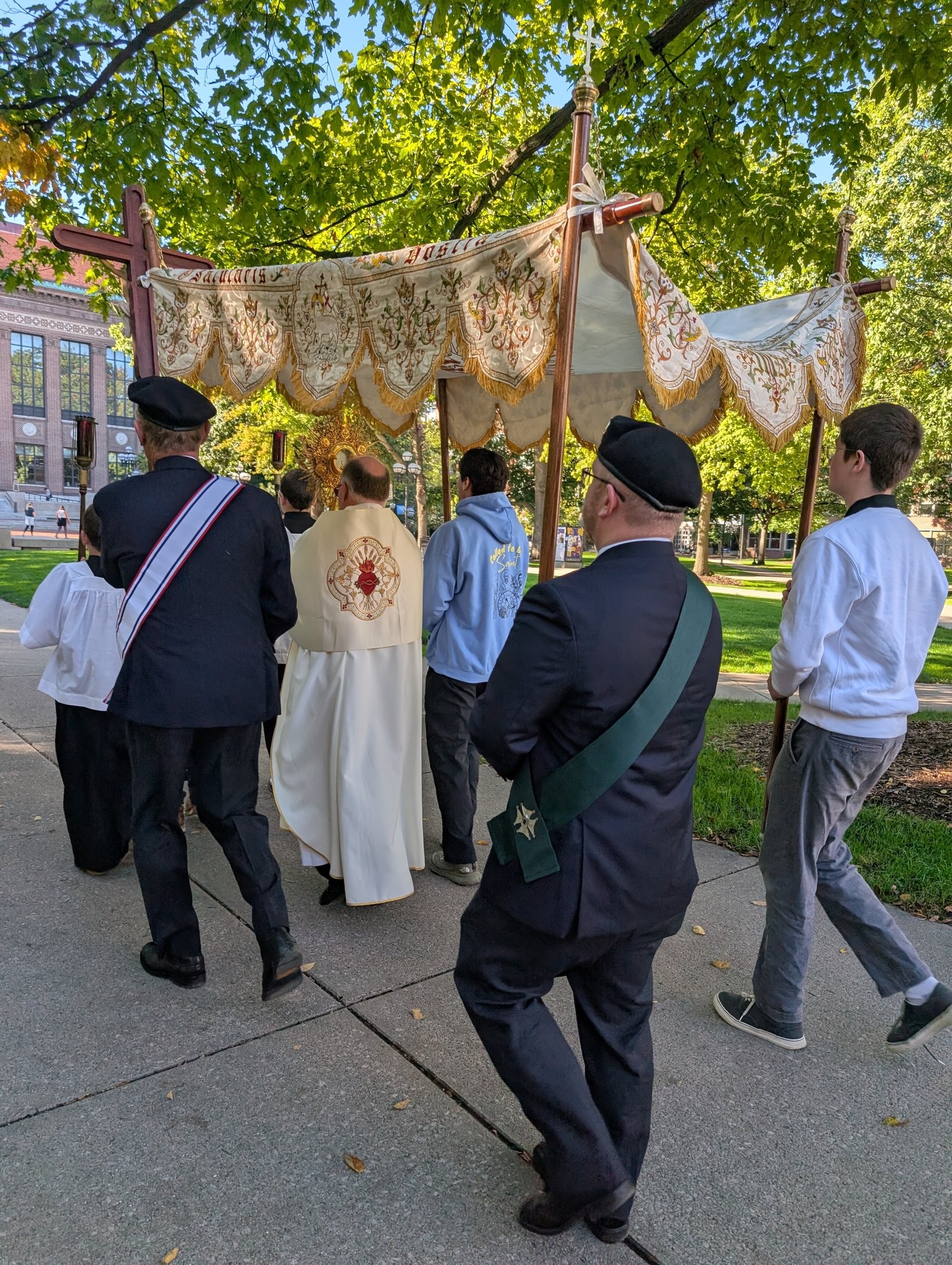 Sir Knights of the Honor Guard walking beside the canopy and monstrance